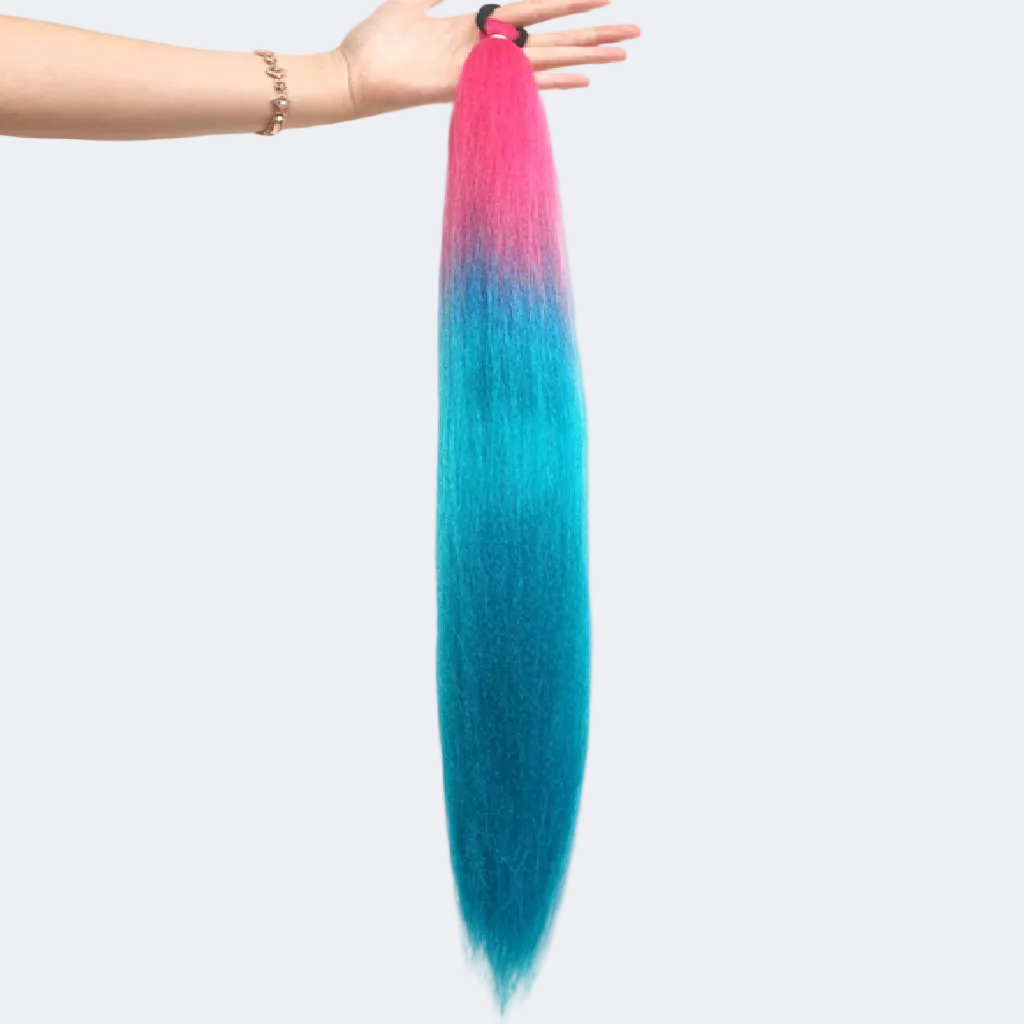 Colorful hair extensions with pink and blue gradient held by a hand on a white background