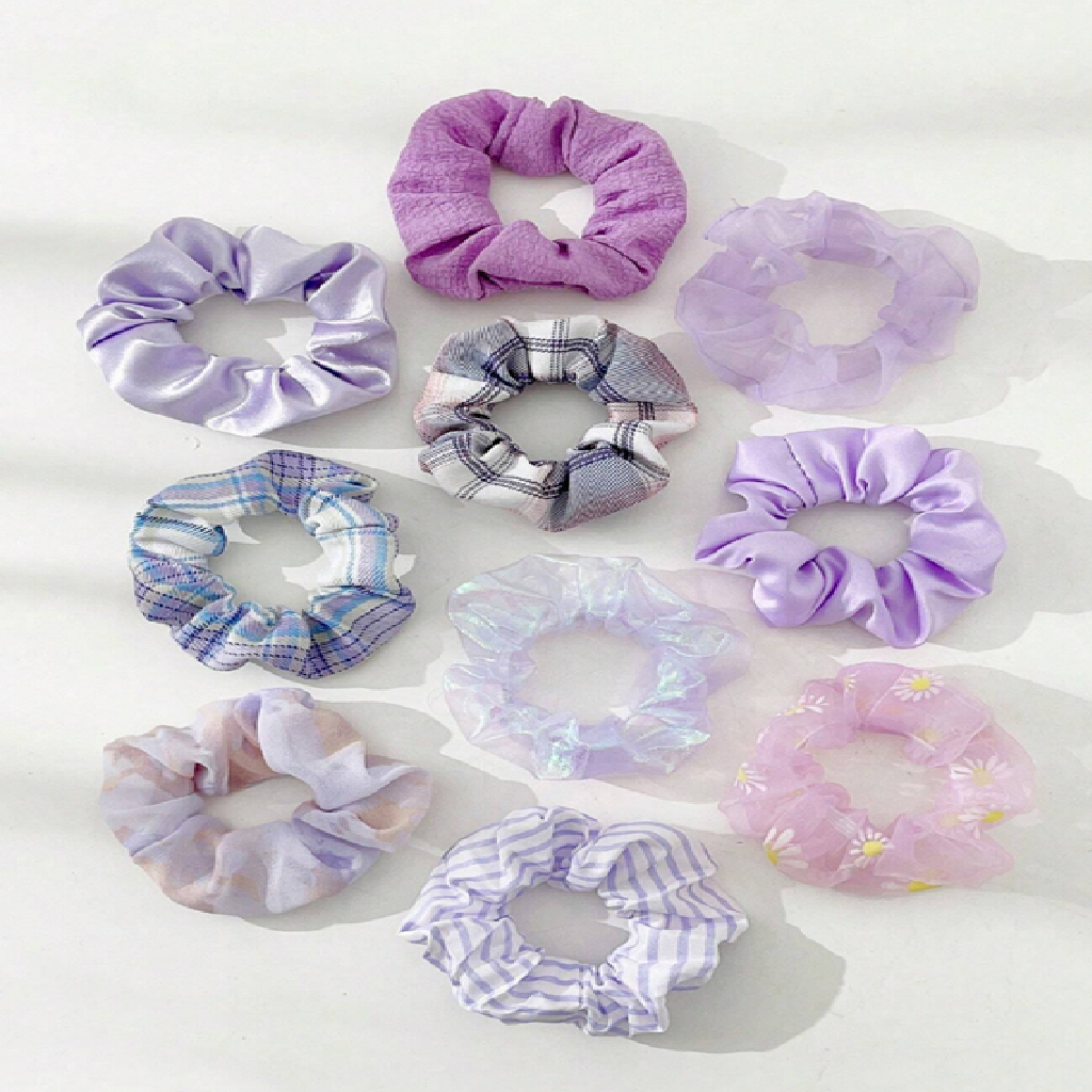 Collection of variously patterned purple scrunchies on a white background