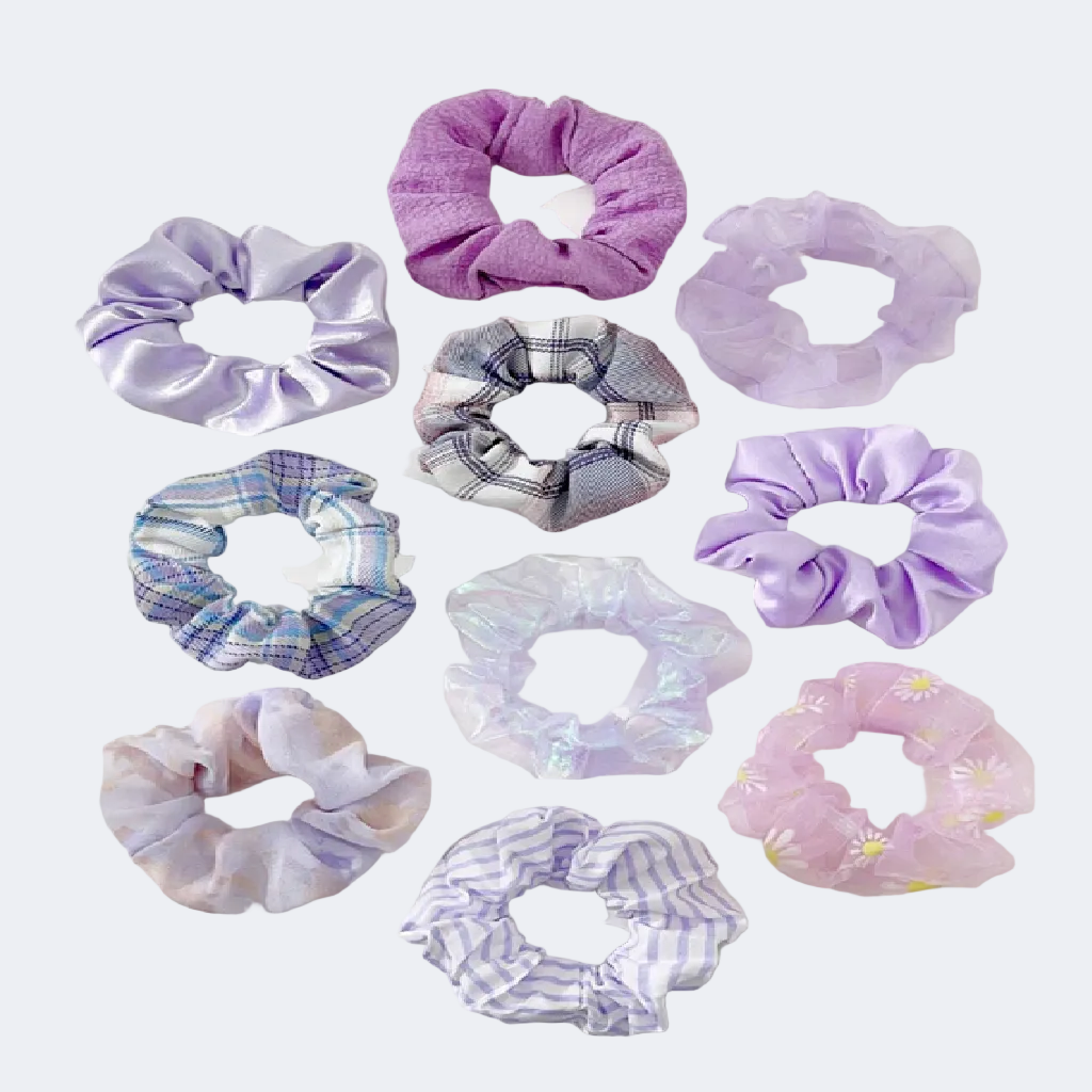 Collection of variously patterned purple scrunchies on a white background