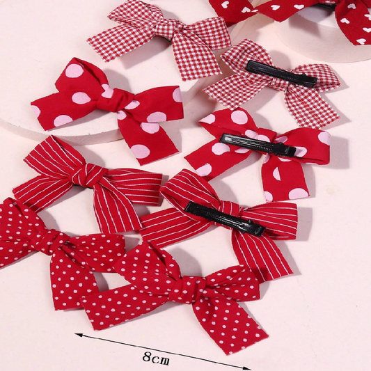 Red and white polka dot hair bows with clips on a light background
