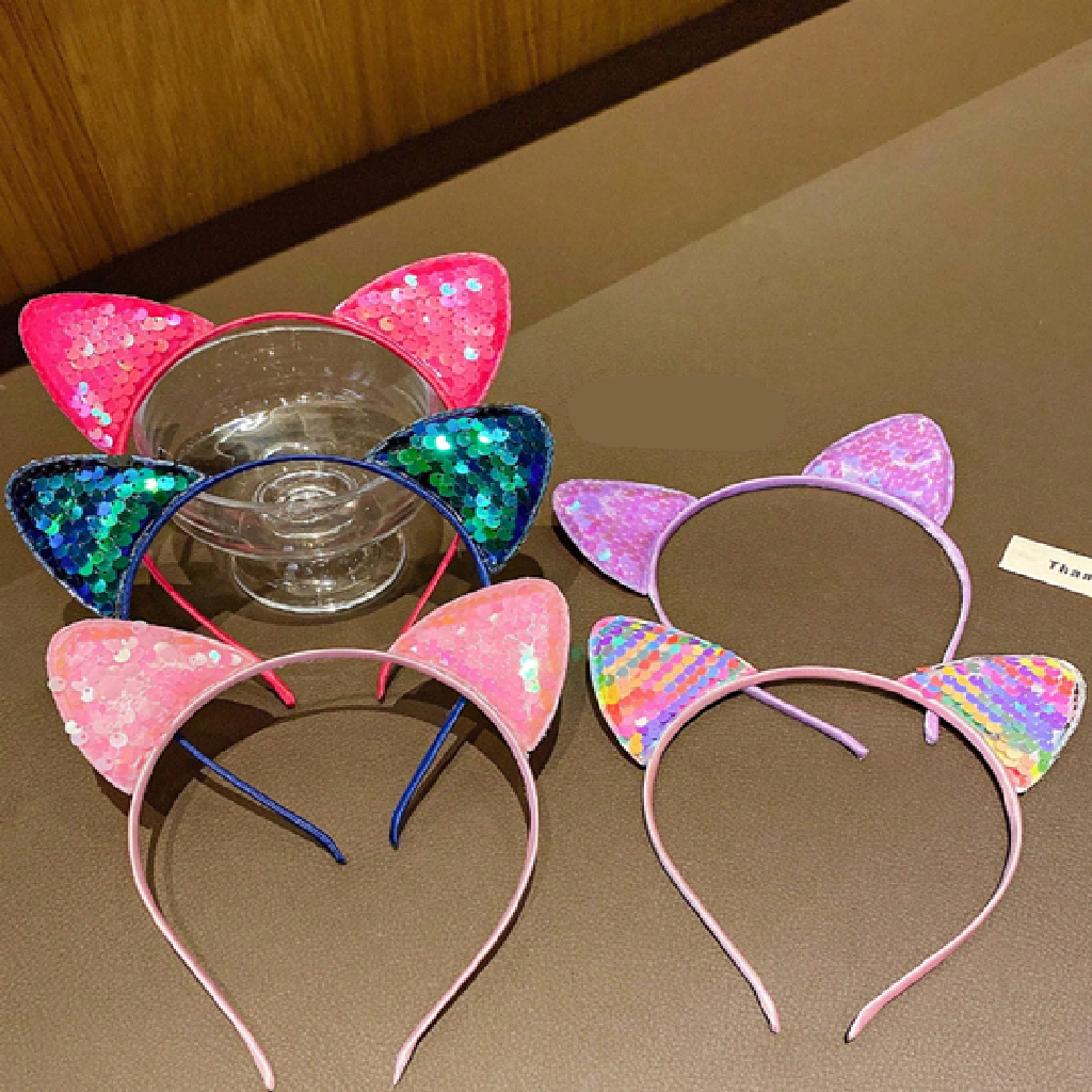 Two colorful cat ear headbands on a brown surface.