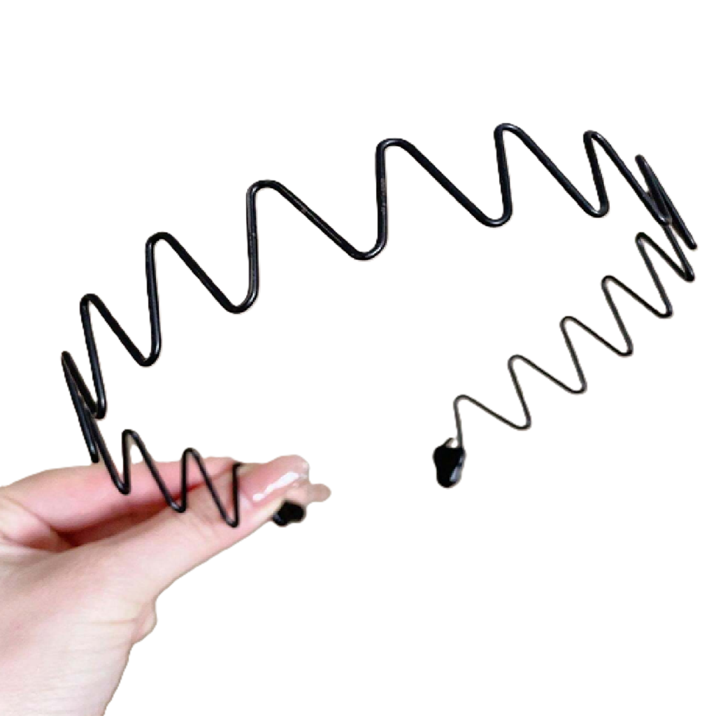 Black hair tie held by a hand on a white background