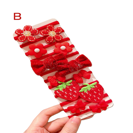 Red and white checkered dress with floral and strawberry designs held by a hand on a white background.