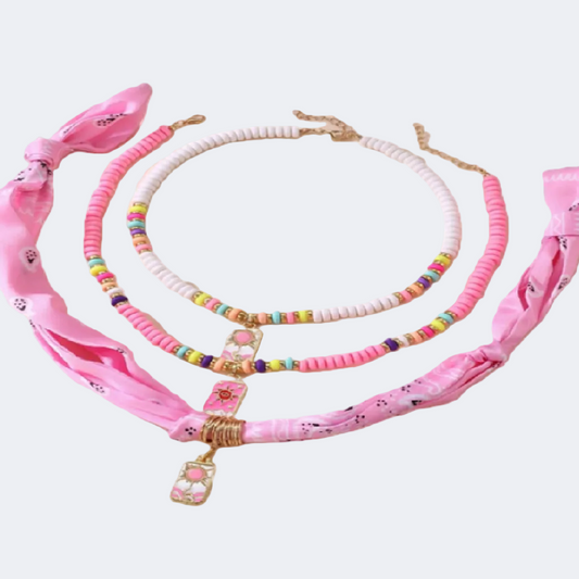 Set of pink accessories including a headband, necklace, and hair tie
