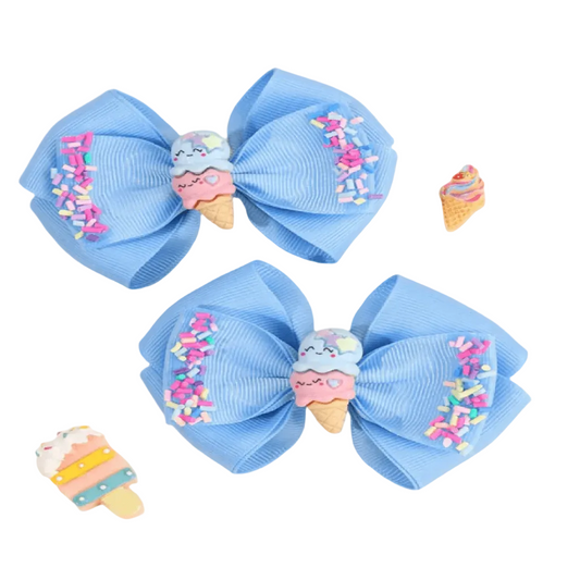 Two blue hair bows with ice cream cone decorations on a light gray background