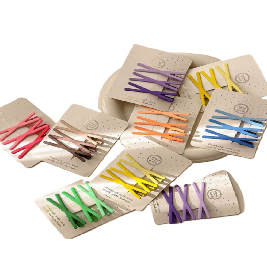 Set of colorful hair clips in their packaging on a white background