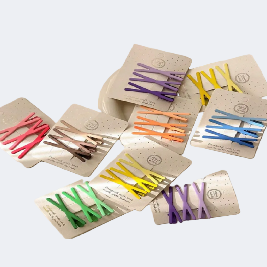 Set of colorful hair clips in their packaging on a white background