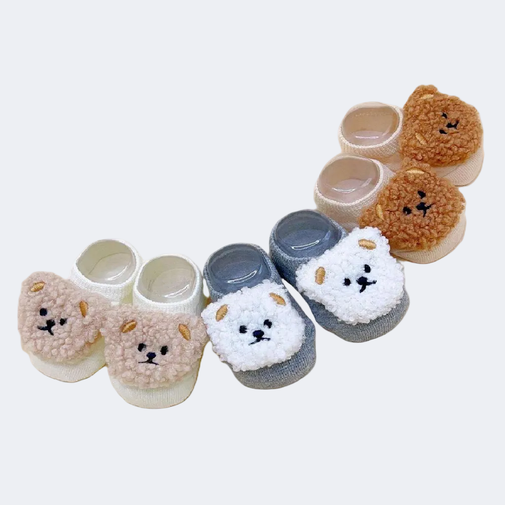 Set of baby shoes with bear face design on a white background