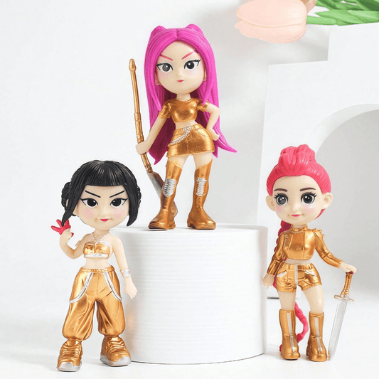 Three action figures in gold and pink outfits on a white background