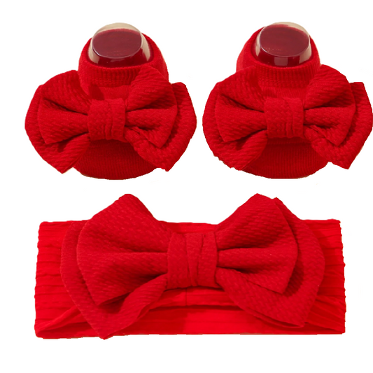 Set of three red knitted bow items on a white background