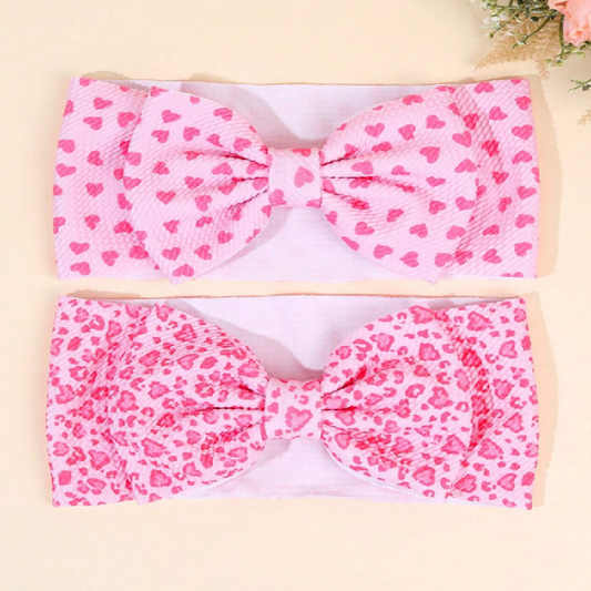 Two pink headbands with heart patterns