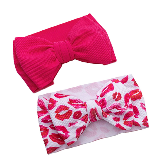 Two headbands with large bows, one pink and one with a red and white pattern, on a white background.