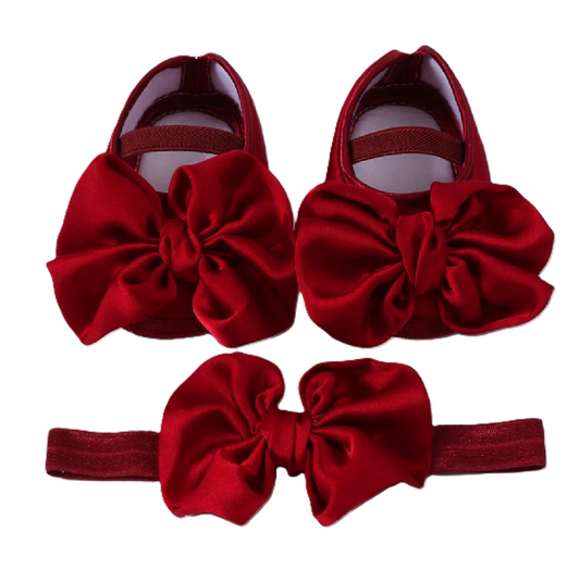 Red baby shoes and headband set on a white background