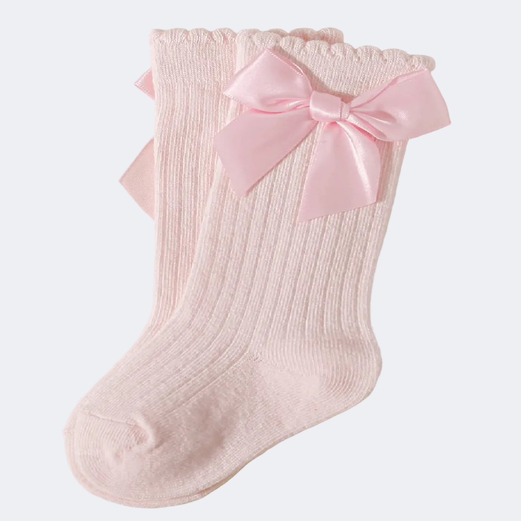 Two pink socks with bow details on a light gray background