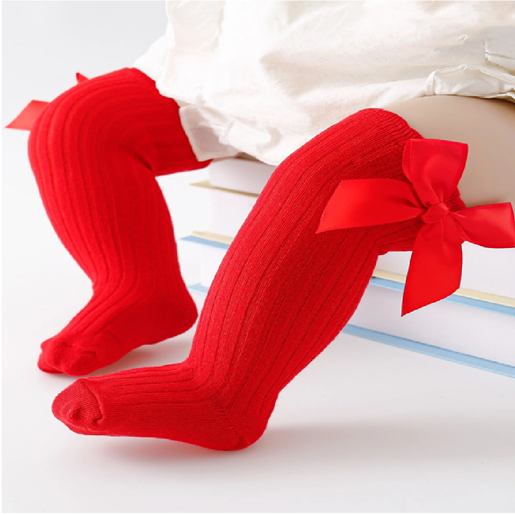 Red knee-high socks with bows worn by a child