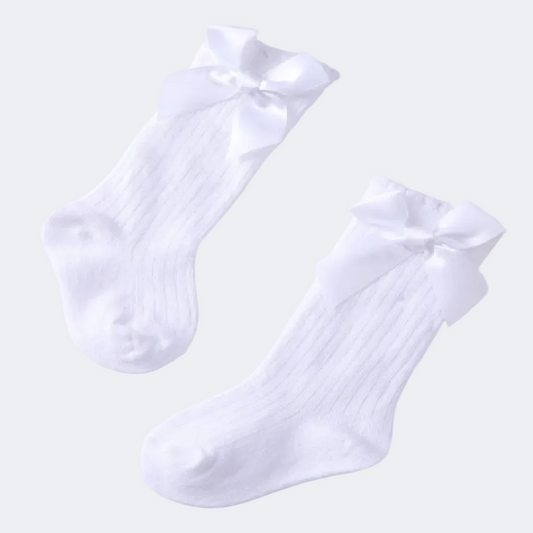Pair of white socks with bow details on a light background