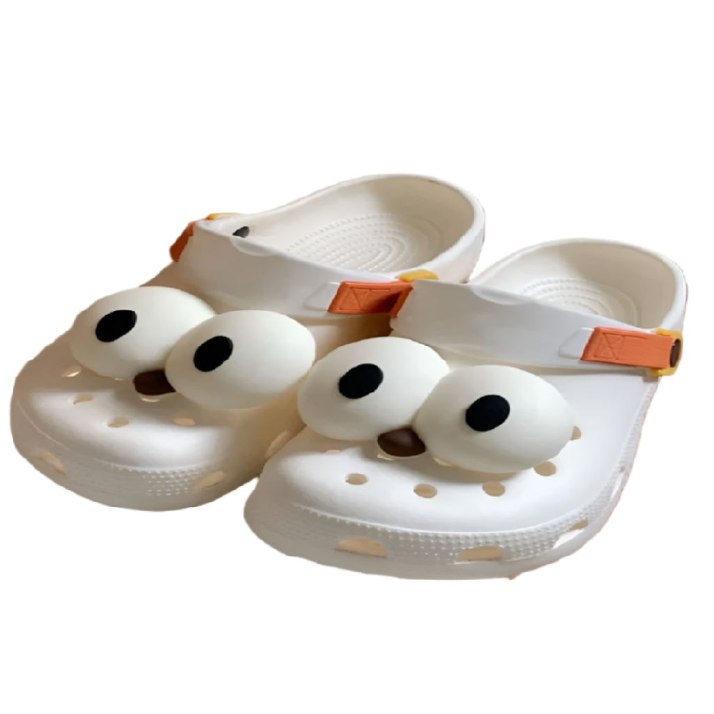 White clogs with cartoonish face design on a white background