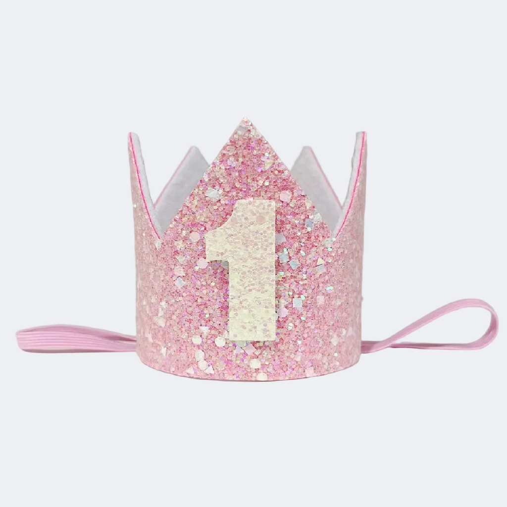 Pink glittery birthday crown with number '1' on a light gray background