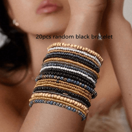 Stack of 20 random black bracelets on a wrist with blurred background