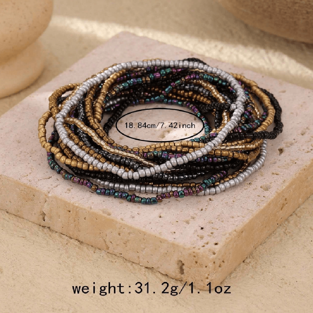 Stack of multicolored beaded bracelets on a textured surface with weight information displayed.