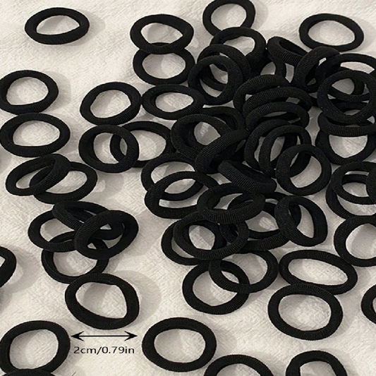 Pile of black hair ties on a white background with measurement label.