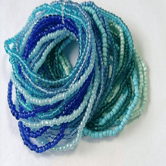 Stack of blue and green beaded bracelets on a white background