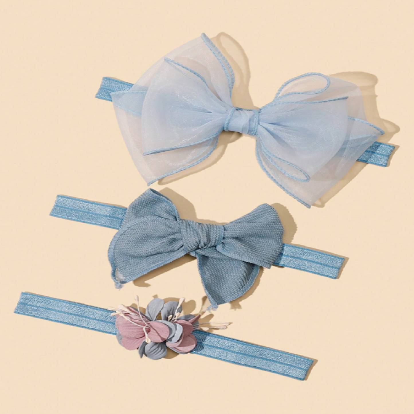 Two blue hair bows with a headband featuring floral details