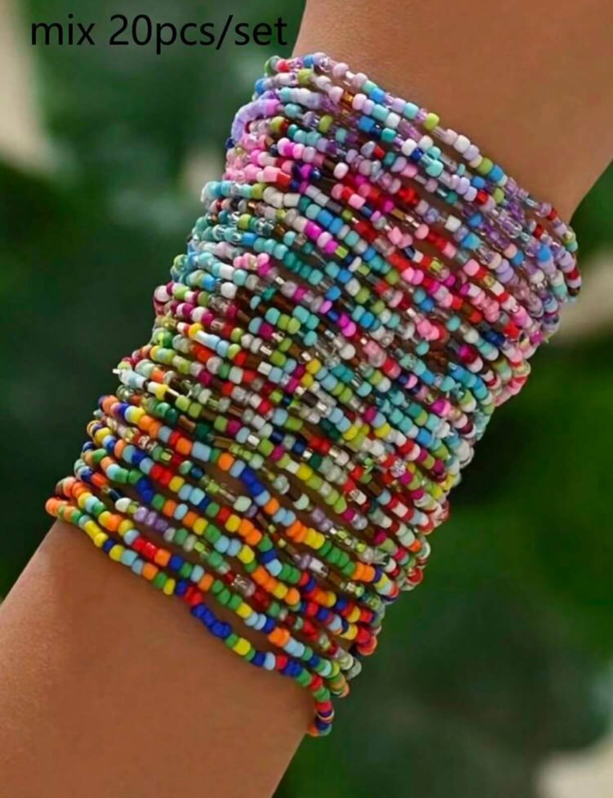 Multicolored beaded bracelet on a wrist with a blurred green background