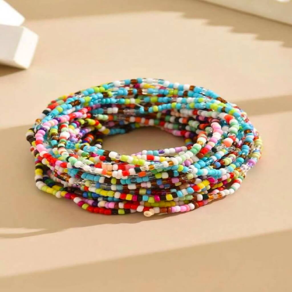 Multicolored beaded bracelets stacked on a beige surface
