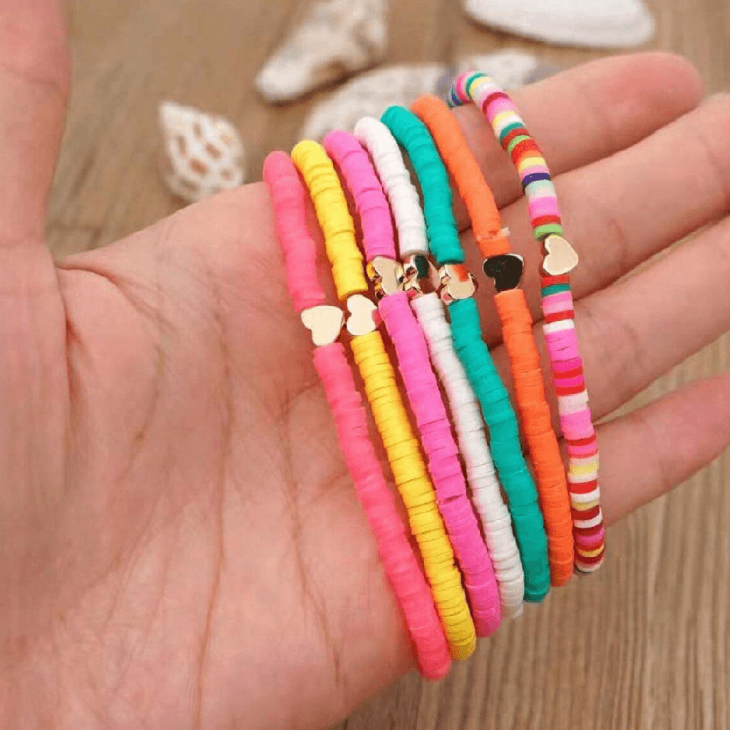 Colorful bracelets on a hand with a wooden background