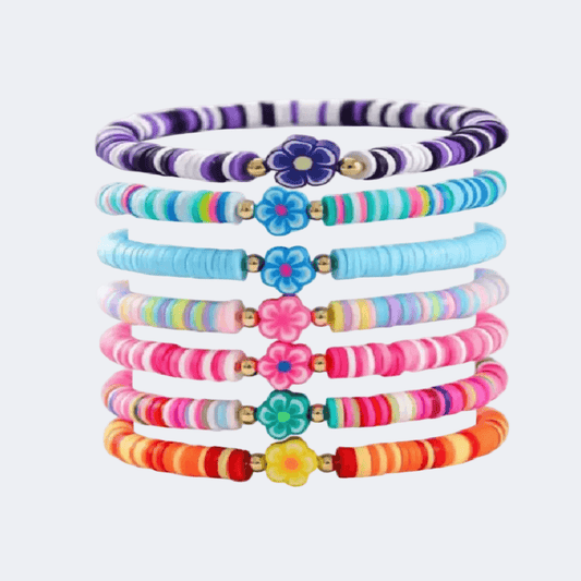 Set of colorful beaded hair ties with floral ends on a white background