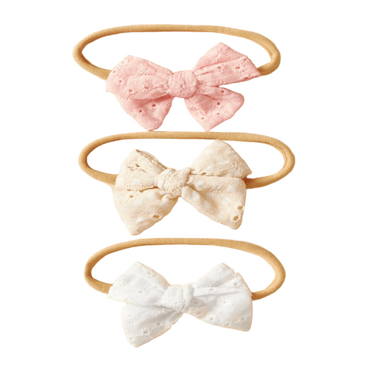 Three headbands with lace bows in pink, white, and beige