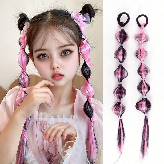 Child with pink and black hair extensions styled in pigtails, next to the extensions on a white background.