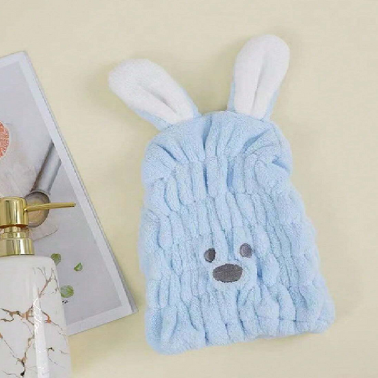 Blue towel with bunny ears and face on a beige background