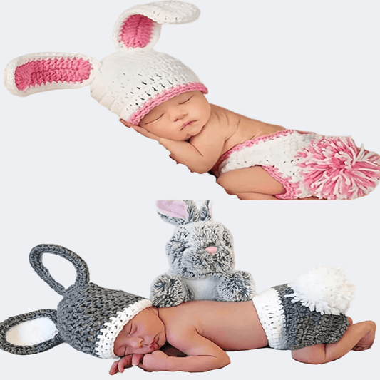 Two baby outfits with bunny ears and tails on a white background