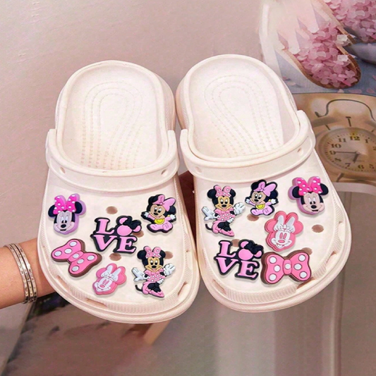 White clogs with decorative charms featuring cartoon characters 