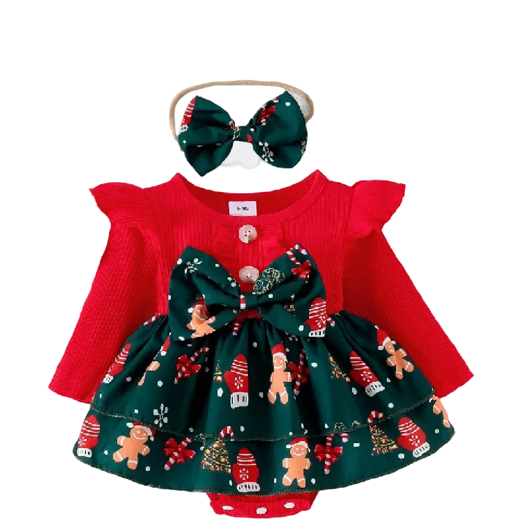 Christmas-themed baby outfit with red top and green skirt, headband, and decorations on a textured surface.