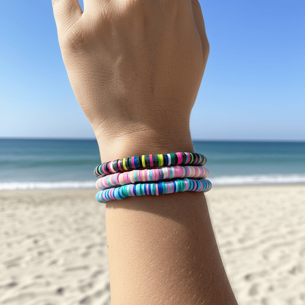 Hand wearing colorful bracelets with a beach background