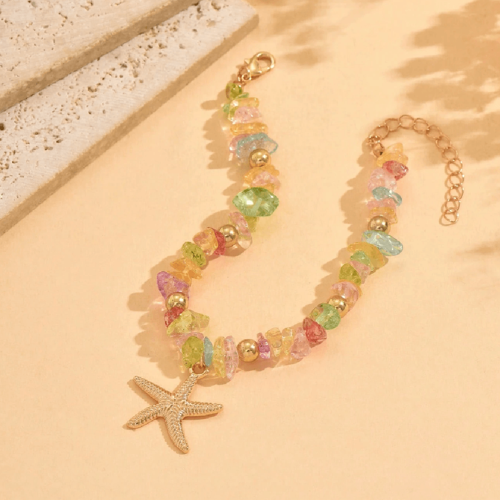 Colorful beaded bracelet with a starfish charm on a beige surface