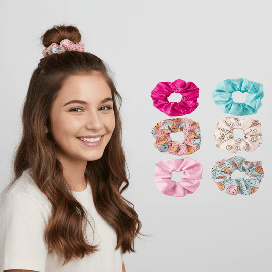 A smiling young woman with long brown hair models a pink scrunchie, with six additional scrunchies shown on the right against a light gray background.