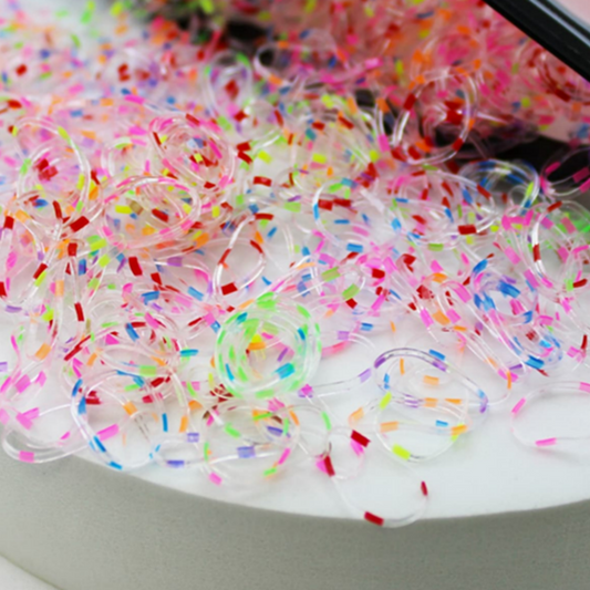 Colorful rubber bands on a white surface with a blurred background