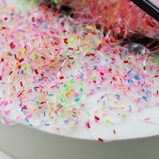 Colorful slime with sprinkles on a white surface
