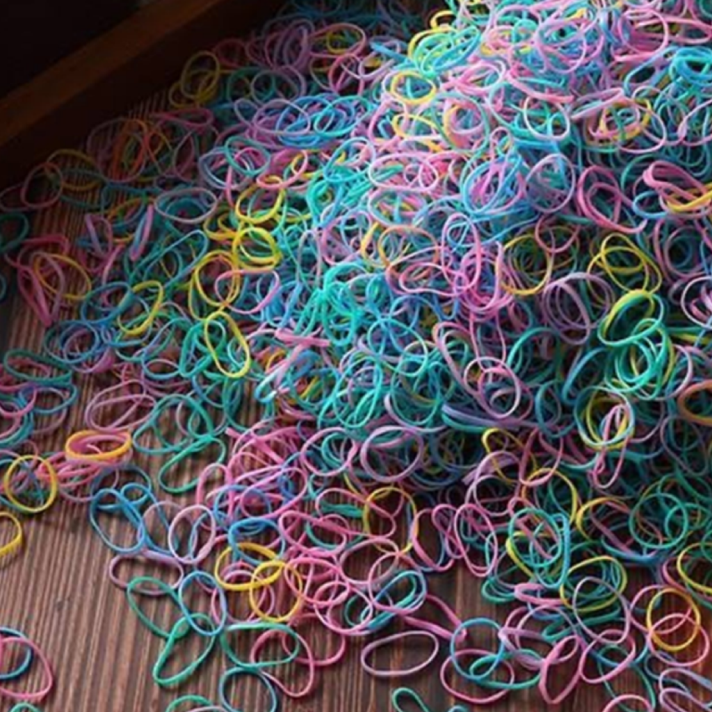 A collection of multicolored disposable hair ties scattered on a surface.