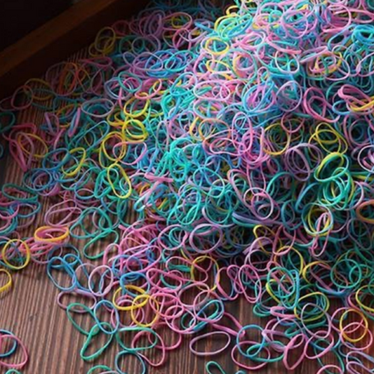 A collection of multicolored disposable hair ties scattered on a surface.