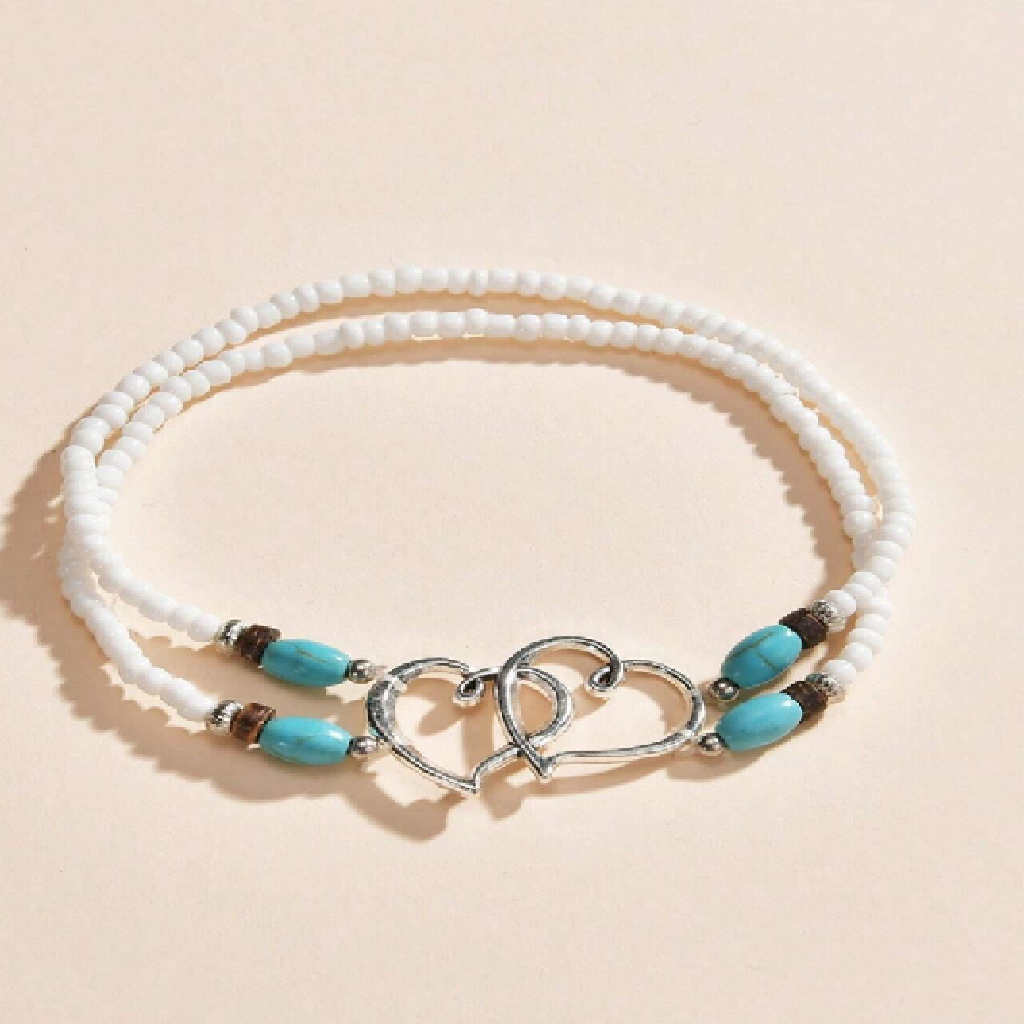 Bracelet with white beads and turquoise stones on a beige background