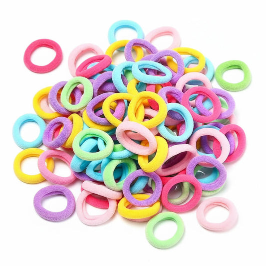 A pile of small foam hair ties in assorted pastel colors, including pink, yellow, blue, green, purple, and orange, arranged on a plain white background.