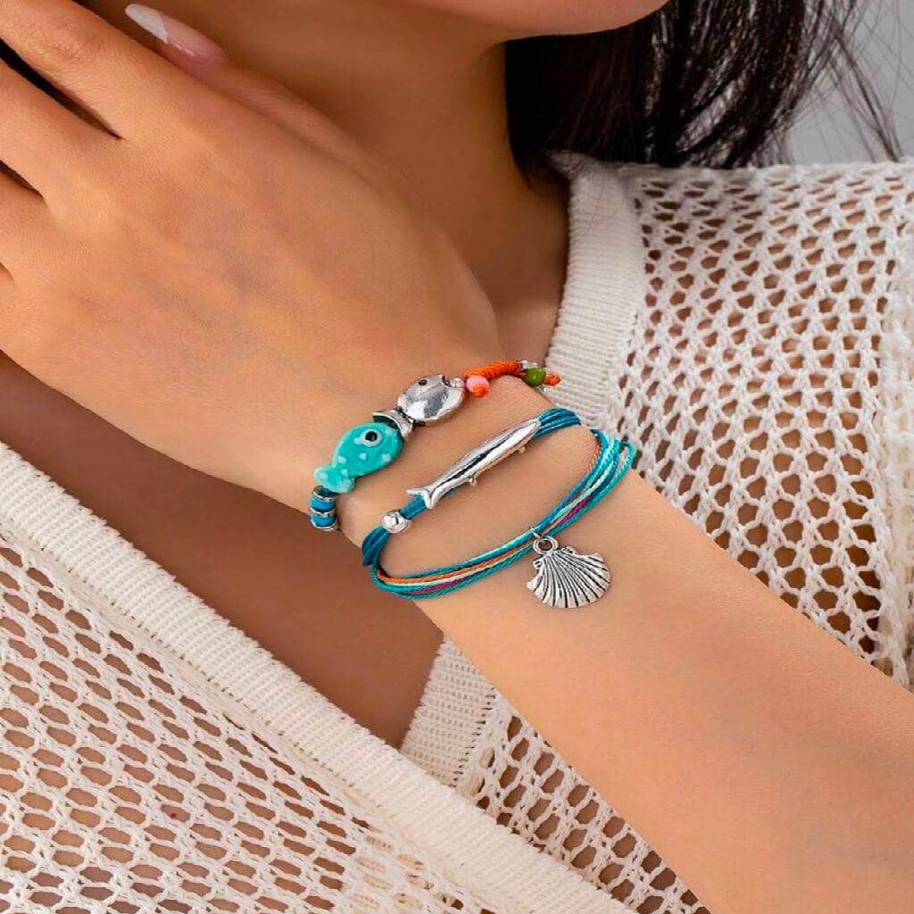 Close-up of a person's wrist wearing multiple colorful bracelets with charms.