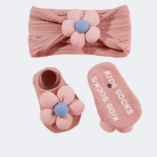 Baby headband and socks set with flower design on a light gray background