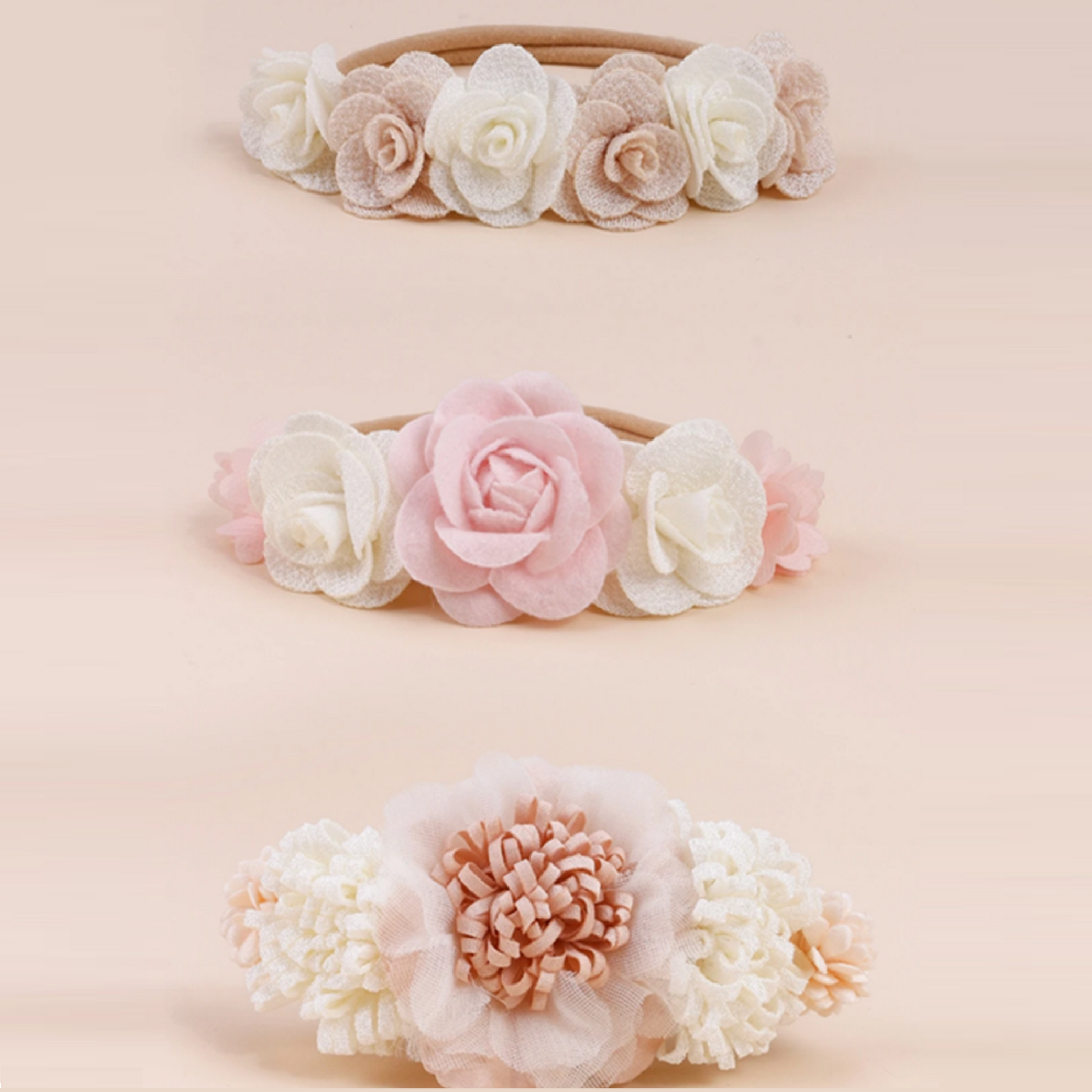 Three floral headbands in different colors on a light peach background.
