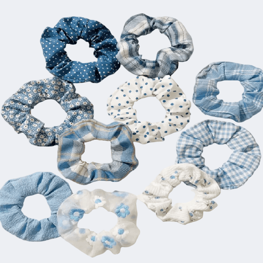 Collection of blue and white scrunchies with various patterns on a light gray background